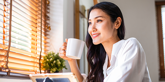 Woman enjoying coffee and looking out window