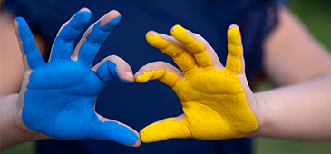 Blue and yellow hands making a heart