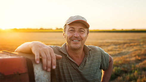 Man smiling and leaning on tractor